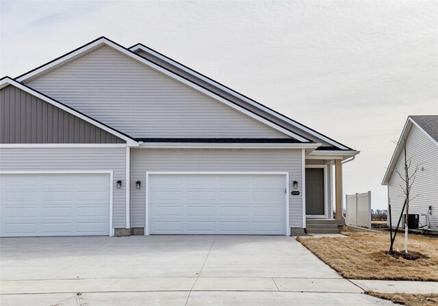 view of front of home featuring a garage, central AC unit, and concrete driveway