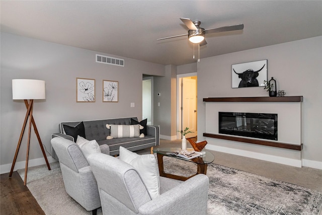 104 Mcpherson St, Boone, IA 50036 - living area featuring a ceiling fan, a glass covered fireplace, and wood finished floors