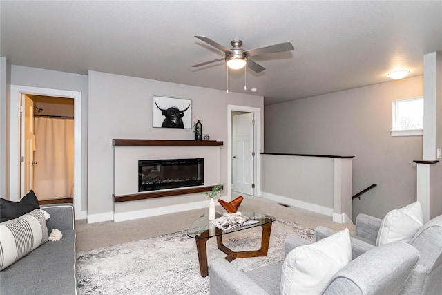 104 Mcpherson St, Boone, IA 50036 - living area with carpet, a ceiling fan, and a glass covered fireplace