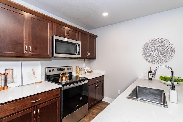 104 Mcpherson St, Boone, IA 50036 - kitchen featuring stainless steel appliances, light countertops, dark wood finished floors, dark brown cabinets, and recessed lighting