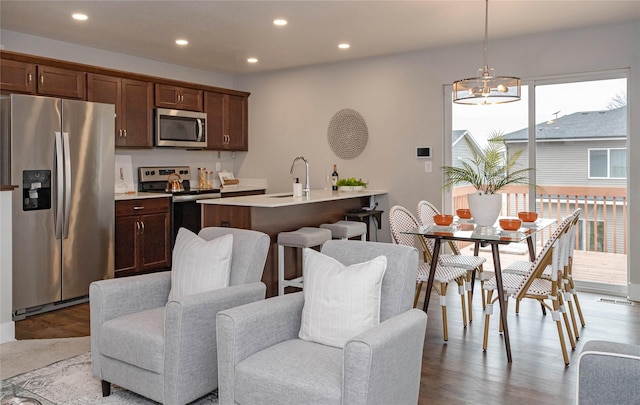 104 Mcpherson St, Boone, IA 50036 - kitchen featuring appliances with stainless steel finishes, a chandelier, light countertops, recessed lighting, and wood finished floors