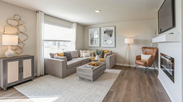 living room featuring light wood-type flooring and baseboards