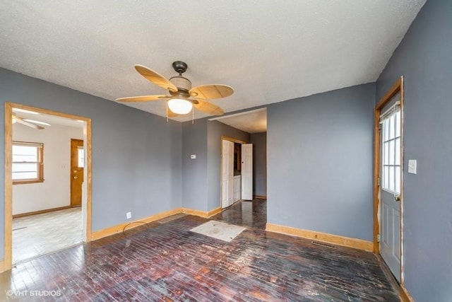 unfurnished room featuring baseboards, wood-type flooring, a textured ceiling, and a ceiling fan