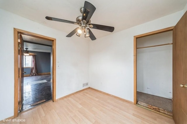 unfurnished bedroom with light wood finished floors, visible vents, baseboards, and a ceiling fan