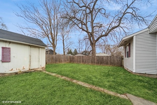 view of yard featuring an outdoor structure and a fenced backyard