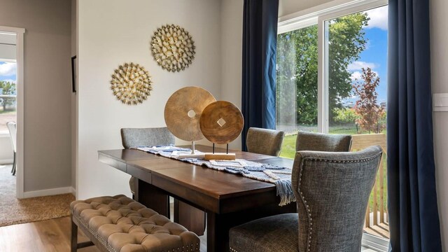 dining area with baseboards and wood finished floors