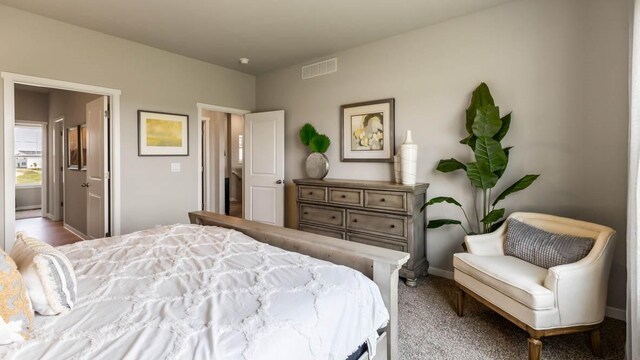 bedroom with visible vents, ensuite bath, and baseboards