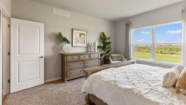 bedroom with visible vents, light carpet, and baseboards