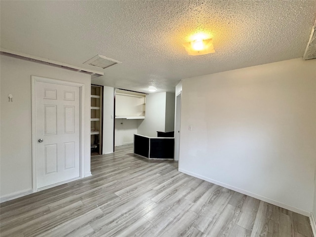 3841 Columbia St, Des Moines, IA 50313 - empty room featuring a textured ceiling, attic access, wood finished floors, and baseboards