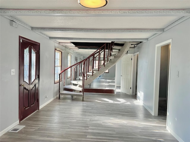 3841 Columbia St, Des Moines, IA 50313 - entrance foyer featuring wood finished floors, stairs, baseboards, and beamed ceiling