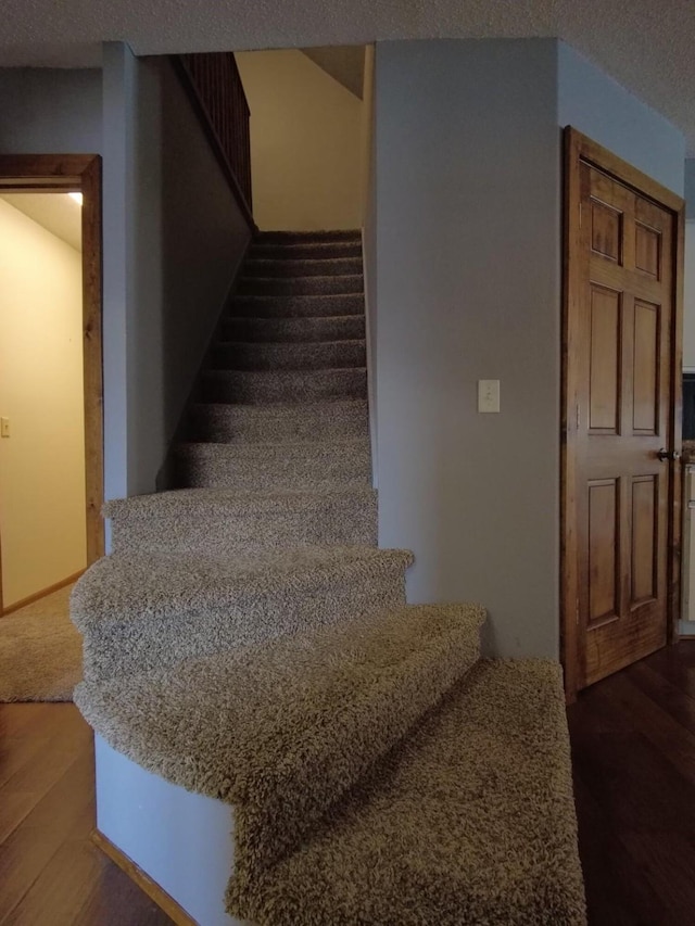 1408 Lincoln St, Gowrie, IA 50543 - stairs with baseboards, wood finished floors, and a textured ceiling