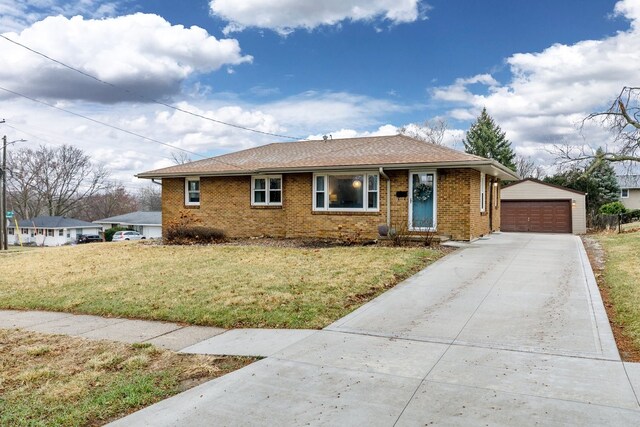 ranch-style house with brick siding, a detached garage, a front yard, roof with shingles, and an outdoor structure