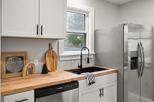 1702 Logan Ave, Des Moines, IA 50316 - kitchen with a sink, white cabinets, stainless steel appliances, and butcher block countertops