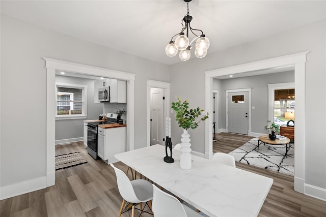 1702 Logan Ave, Des Moines, IA 50316 - dining space featuring an inviting chandelier, baseboards, and wood finished floors