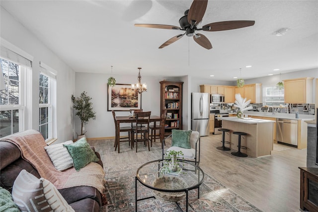 5558 Boston Ct, Johnston, IA 50131 - living area with light wood finished floors, a ceiling fan, a chandelier, and recessed lighting