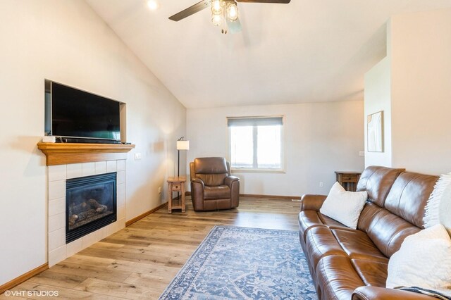 living room featuring a tile fireplace, a ceiling fan, lofted ceiling, and wood finished floors