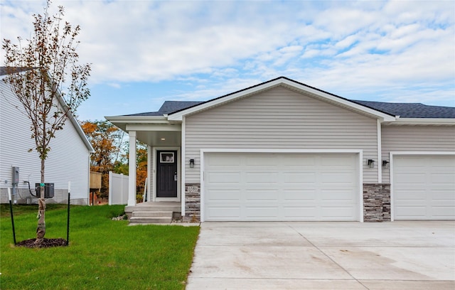 2717 13th St NE, Bondurant, IA 50035 - view of front of home featuring stone siding, a garage, concrete driveway, and roof with shingles