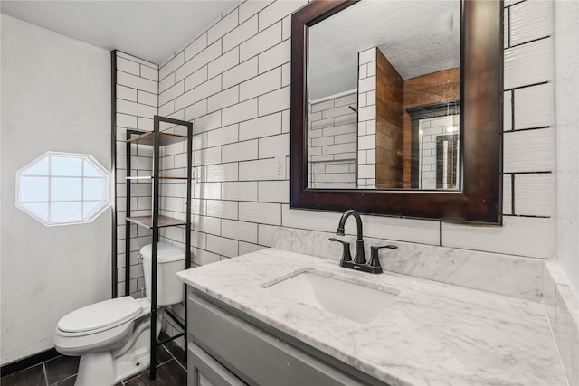951 24th St, Des Moines, IA 50312 - bathroom featuring toilet, vanity, and tile walls