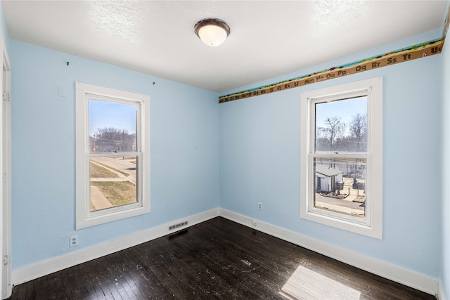 951 24th St, Des Moines, IA 50312 - empty room with healthy amount of natural light, dark wood finished floors, and baseboards
