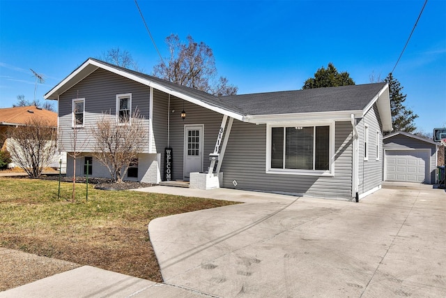tri-level home with an outbuilding, a front yard, and driveway
