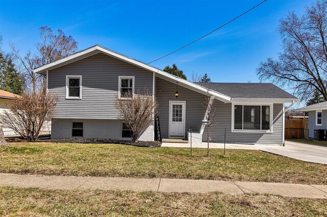 split level home with cooling unit, a front lawn, and fence