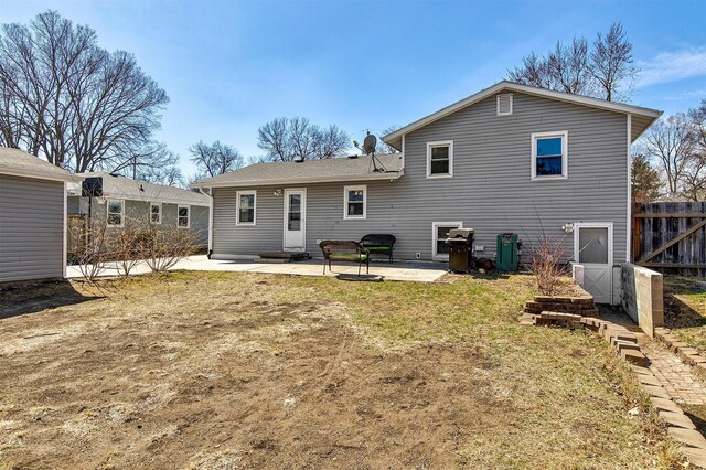 rear view of house with a patio, a lawn, and fence