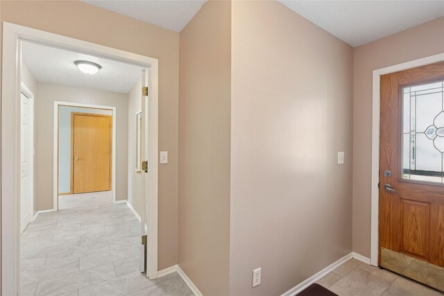 entrance foyer featuring light tile patterned floors and baseboards