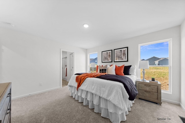 bedroom with baseboards and light colored carpet