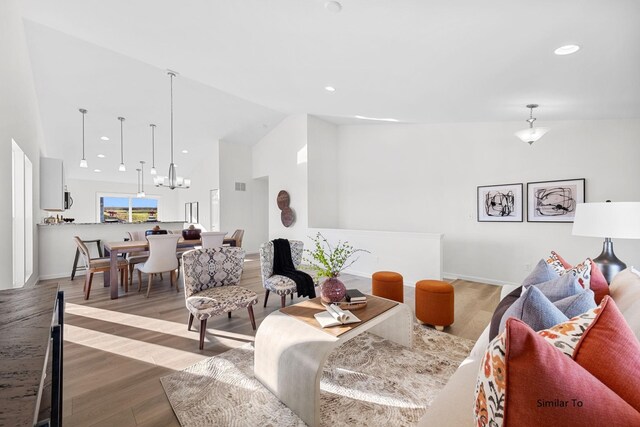 living area featuring high vaulted ceiling, a chandelier, wood finished floors, baseboards, and recessed lighting