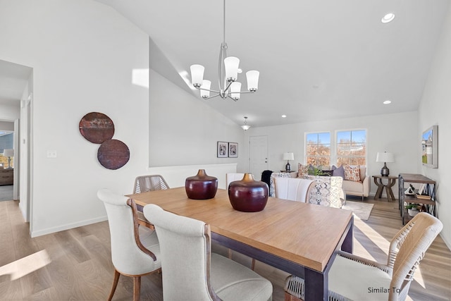 dining space featuring light wood-type flooring, a chandelier, recessed lighting, baseboards, and high vaulted ceiling