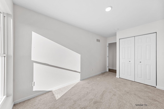 unfurnished bedroom featuring carpet, baseboards, a closet, and recessed lighting