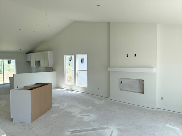 kitchen featuring high vaulted ceiling, white cabinetry, and a center island