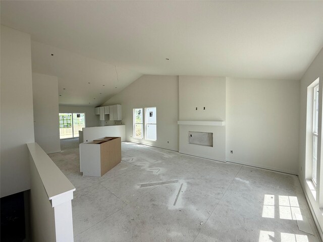 unfurnished living room featuring lofted ceiling and a fireplace