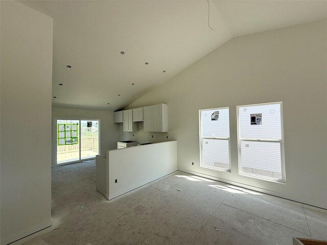 unfurnished living room with high vaulted ceiling