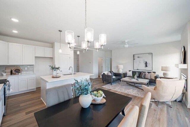 125 NW Rolling Cir, Waukee, IA 50263 - dining space with a chandelier, a ceiling fan, wood finished floors, and recessed lighting