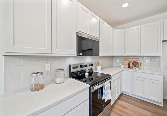 125 NW Rolling Cir, Waukee, IA 50263 - kitchen with appliances with stainless steel finishes, white cabinetry, light wood-style floors, light stone counters, and recessed lighting