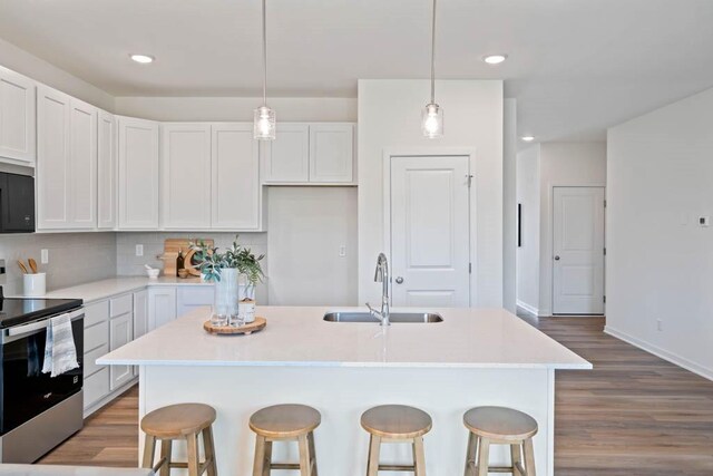 125 NW Rolling Cir, Waukee, IA 50263 - kitchen featuring electric stove, light wood-style floors, a breakfast bar, white cabinets, and tasteful backsplash