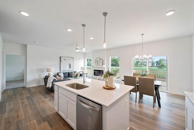 125 NW Rolling Cir, Waukee, IA 50263 - kitchen with dishwasher, a glass covered fireplace, light countertops, wood finished floors, and recessed lighting