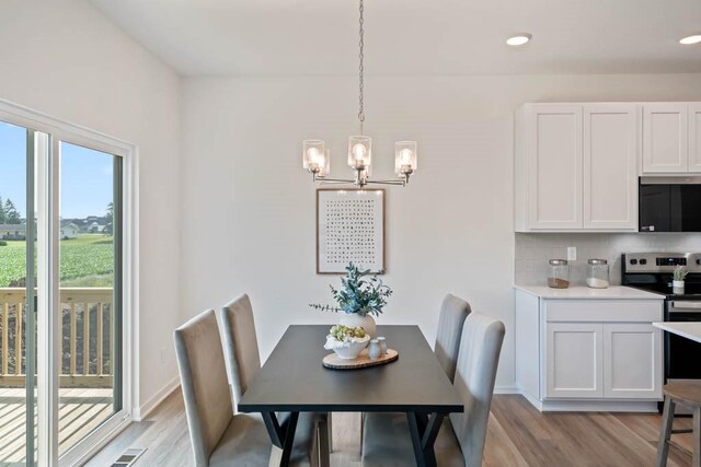 125 NW Rolling Cir, Waukee, IA 50263 - dining room featuring a chandelier, light wood-type flooring, and recessed lighting
