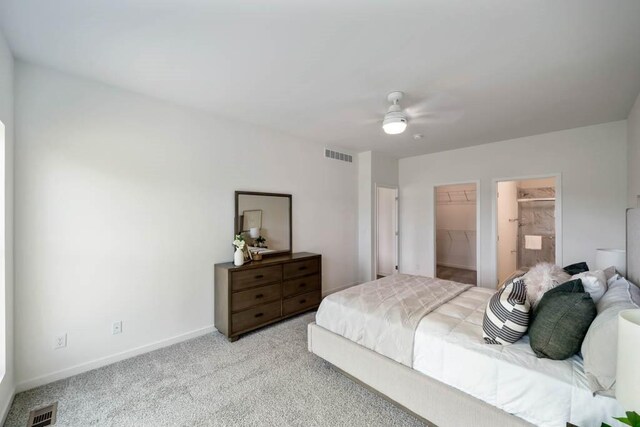 125 NW Rolling Cir, Waukee, IA 50263 - bedroom featuring light colored carpet, a walk in closet, a closet, a ceiling fan, and ensuite bath