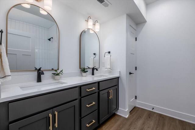 1296 Bee Tree Ln, Ellston, IA 50074 - bathroom featuring double vanity, wood finished floors, baseboards, and a shower