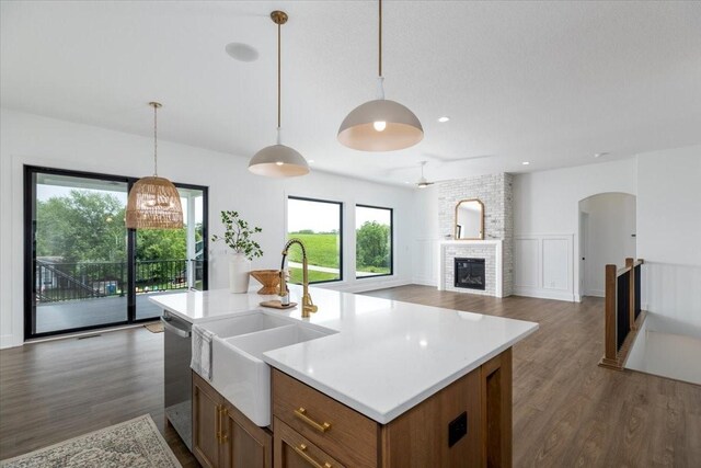 1296 Bee Tree Ln, Ellston, IA 50074 - kitchen featuring a sink, stainless steel dishwasher, light countertops, brown cabinets, and dark wood finished floors