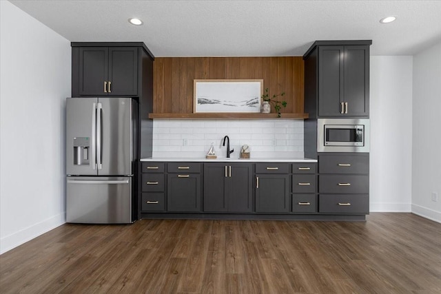 1296 Bee Tree Ln, Ellston, IA 50074 - kitchen featuring stainless steel appliances, light countertops, a sink, baseboards, and backsplash