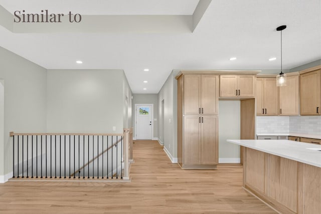 2926 Lake Hill Dr, Des Moines, IA 50320 - kitchen with light brown cabinetry, light wood-style flooring, light countertops, tasteful backsplash, and decorative light fixtures
