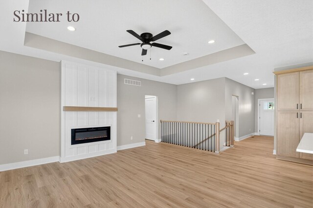 2926 Lake Hill Dr, Des Moines, IA 50320 - unfurnished living room featuring light wood-style floors, a tray ceiling, ceiling fan, recessed lighting, and a fireplace