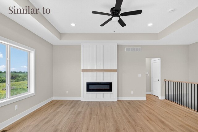 2926 Lake Hill Dr, Des Moines, IA 50320 - unfurnished living room featuring light wood finished floors, a fireplace, a raised ceiling, a ceiling fan, and recessed lighting