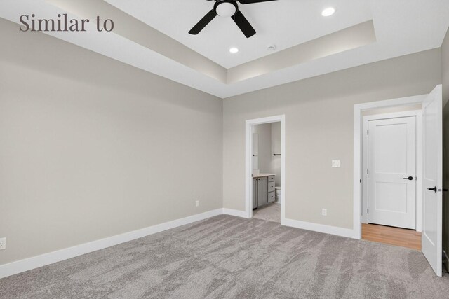 2926 Lake Hill Dr, Des Moines, IA 50320 - unfurnished bedroom with light carpet, a tray ceiling, recessed lighting, ensuite bathroom, and ceiling fan