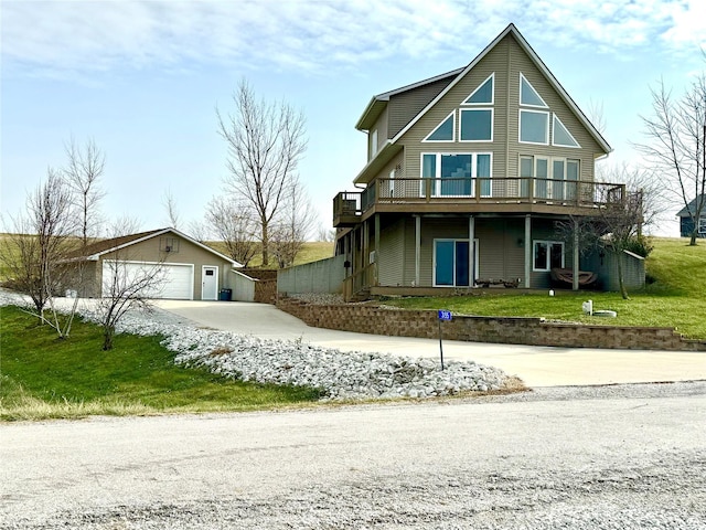 view of front of property with a deck, a front yard, and concrete driveway