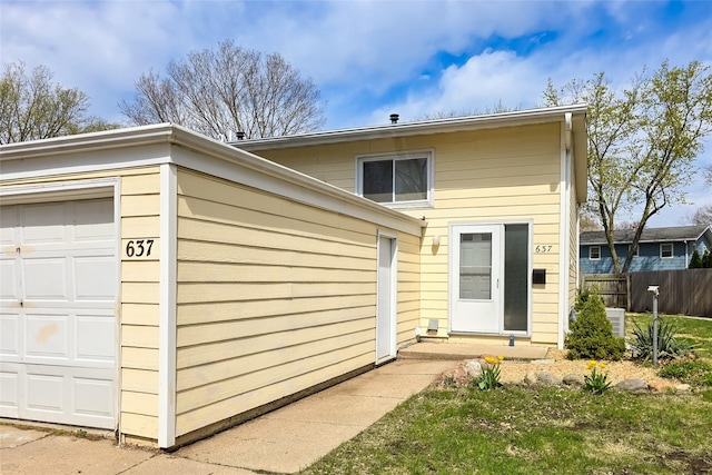 view of front of home featuring an attached garage and fence