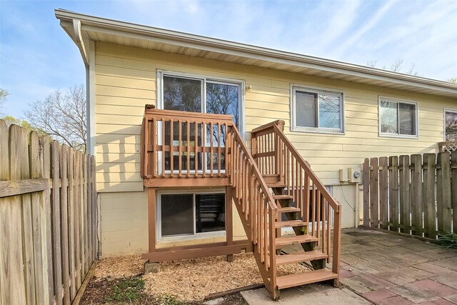 rear view of property featuring fence and a wooden deck